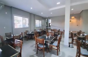 a restaurant with tables and chairs in a room at Hotel Mohallem in Passos