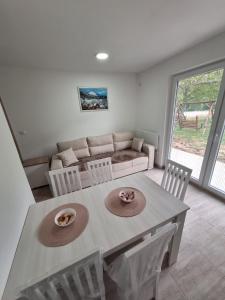 a living room with a table and a couch at Apartmani Milojević in Boljevac