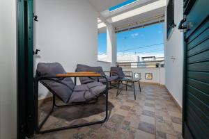 a balcony with chairs and a table and a window at Casa Pescoluse 50m dal Mare in Marina di Pescoluse