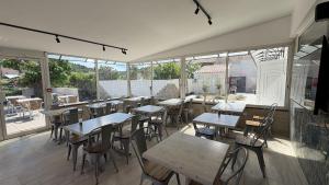 an empty restaurant with tables and chairs and windows at Rovotel - Le Rove in Le Rove