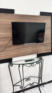 a flat screen tv sitting on top of a table at Casa a 8 minutos do Parque do Povo - Campina Grande PB in Campina Grande