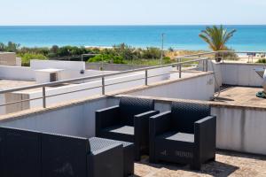 a balcony with chairs and the beach in the background at Casa Pescoluse 50m dal Mare in Marina di Pescoluse