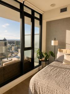 a bedroom with a bed and a large window at The Alpine City Escape in Calgary +12 photos