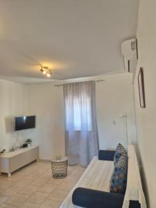 a room with a bed and a tv and a couch at Apartments Mikecin in Novigrad Dalmatia