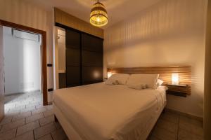 a bedroom with a large bed and a light fixture at Casa Pescoluse 50m dal Mare in Marina di Pescoluse