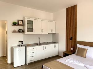 a bedroom with a sink and white cabinets at Apartments Klajdi in Sarandë