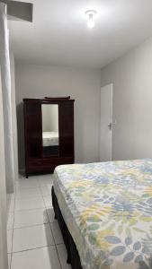 a bedroom with a bed and a dresser and a mirror at Casa a 8 minutos do Parque do Povo - Campina Grande PB in Campina Grande