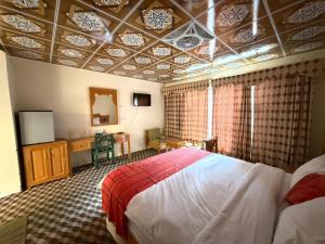 a bedroom with a bed and a tv in a room at Ameer lodge in Hunza Valley +35 photos