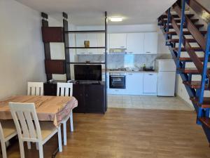a kitchen and dining room with a table and a staircase at Sunset Zaglav Apartment in Martinšćica