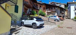 a white car parked next to a building at Appartamento EDELWEISS in Baselga di Pinè