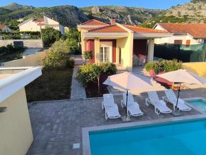 a house with a swimming pool with chairs and umbrellas at Villa Bona - Private Pool Oasis in Mostar