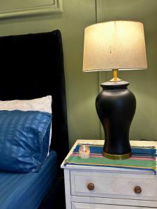 a lamp on a night stand next to a bed at River Hill in Rawalpindi