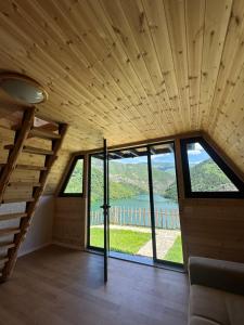 a room with large windows and a staircase in a house at Camping Temali T&M in Arrëz