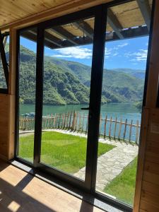 a window view of a lake from a cabin at Camping Temali T&M in Arrëz