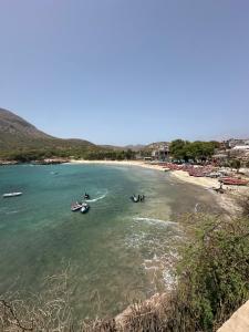 people in boats in the water on a beach at Recanto da Paz in Tarrafal