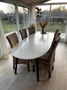 a white dining table and chairs in a room at Charming House Close To The Beach in Gedser