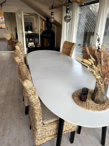 a white dining room table with wicker chairs at Charming House Close To The Beach in Gedser