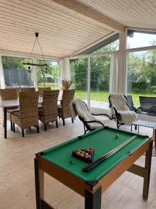 a living room with a pool table and chairs at Charming House Close To The Beach in Gedser