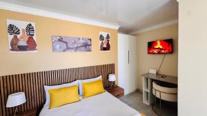 a bedroom with a bed with yellow pillows at Jwalaboholo Mountain View Guest House in Ficksburg