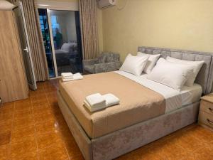 a bedroom with a bed with two towels on it at Dina's Rooms Himara in Himare