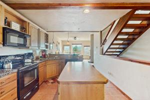 a large kitchen with wooden cabinets and a staircase at View House in Fraser