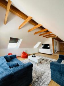 a living room with two blue couches and a table at Ferienhäuser Radebeul "Maisonette Klein Nizza" in Radebeul