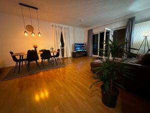 a living room with a table and chairs and a couch at Lesum View Apartment Bremen in Bremen