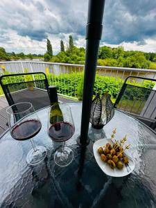 a table with two glasses of wine and a plate of food at Lesum View Apartment Bremen in Bremen
