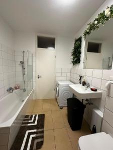 a bathroom with a sink and a tub and a toilet at Lesum View Apartment Bremen in Bremen +21 photos