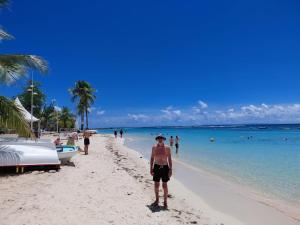 a man standing on a beach next to the ocean at Nid du Lagon in Sainte-Anne +1 photo