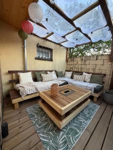 a living room with a couch and a table at Studio chaleureux, massage, terrasse privé, barbecue et balneo in Cussac-Fort-Medoc