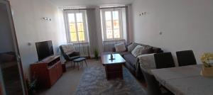a living room with a couch and a tv at Apartmán Náměstí Hostinné in Hostinné