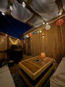 a room with a table and lights on the ceiling at Studio chaleureux, massage, terrasse privé, barbecue et balneo in Cussac-Fort-Medoc