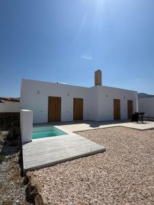 a house with a swimming pool next to a building at Elysian Sea View New Golden Beach Piso Livadi in Chrissi Akti