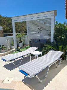 a couple of white lounge chairs on a patio at Secret Paradise in Koutsounari
