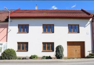 a white house with a brown roof at Dům U babičky in Laškov