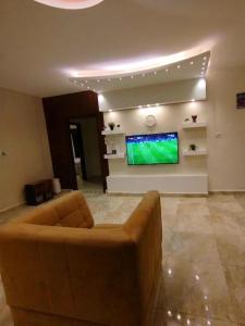 a living room with a couch and a flat screen tv at مزرعة لافين in Jerash