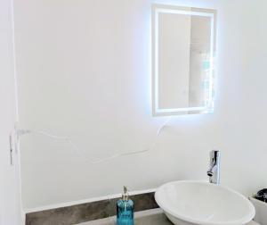 a white bathroom with a sink and a mirror at Chepicche Inn in Oaxaca City
