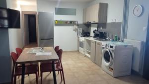 a kitchen with a table and a washing machine at House with garden in Agria +5 photos
