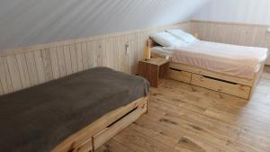 a bedroom with two twin beds and wooden floors at Dom nad jeziorem Serwy in Serwy