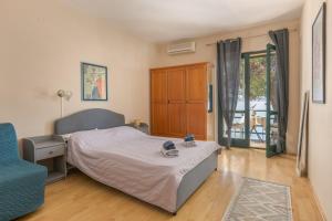 a bedroom with a bed and a blue chair at PINE&SHINE Waterfront in Podgora