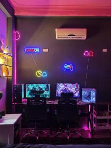 a room with a table with two monitors and neon signs at VV House and Cinema 2 in Quy Nhon +18 photos
