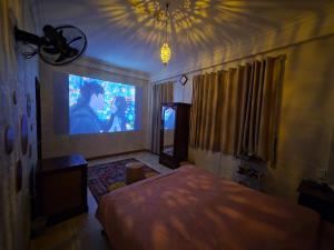 a bedroom with a bed and a large screen at VV House and Cinema 2 in Quy Nhon