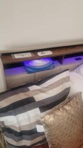 a shelf above a bed with a pillow and controllers at Petit appartement avec jacuzzi in Bédarrides +4 photos