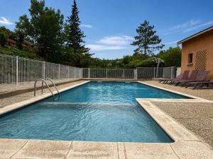 a swimming pool with blue water in a yard at Maison proche vallon pont d arc in Salavas