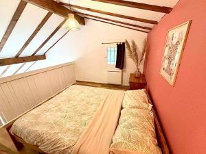 a bedroom with a bed and a red wall at Maison proche vallon pont d arc in Salavas +7 photos