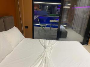 a bedroom with a bed with white sheets and a window at Aurora villa in Rrushkull