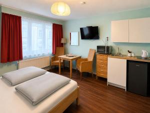 a room with a bed and a kitchen with a table at Dana Living Apartment Bremen HBF - Zentrum, Altstadt, Messe, ÖVB Arena, Business Apartment mit Self Check-in in Bremen