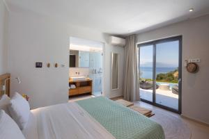 a bedroom with a bed and a view of the ocean at Kechria Bay Villas in Skiathos