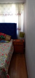 a bedroom with a bed and a table with a lamp at José Coro in La Serena